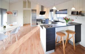 a kitchen and dining room with a table and chairs at Three-Bedroom Holiday Home In Hvide Sande in Bjerregård