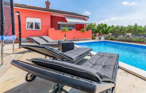 un gruppo di sedie sedute accanto a una piscina di 3 Bedroom Awesome Home In Marcana a Marčana Altre 35 foto