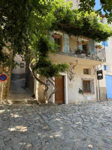 a building with a tree in front of a street at Chez Marco Gîte & SPA CAPPELLINA in Muro