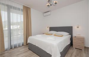 a white bedroom with a large bed and a window at Gorgeous Home In Brela in Brela