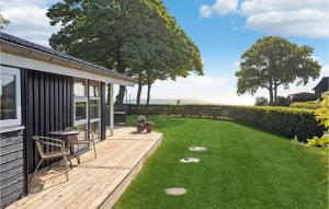 a backyard with a deck with a putting green at Holiday Home Grønningen Børkop Denm in Egeskov