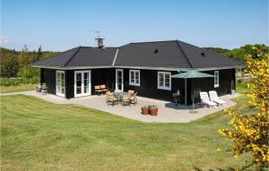 a black house with a patio and a table at Holiday Home Ravnsvej Ebeltoft Denm in Ebeltoft +24 photos