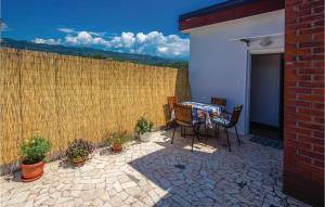 a patio with a table and chairs and a fence at Gorgeous Apartment In Crikvenica in Crikvenica +18 photos