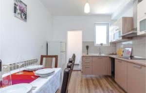 a kitchen with a table with plates on it at Gorgeous Apartment In Crikvenica in Crikvenica