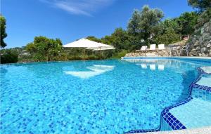 a large blue swimming pool with an umbrella at Lovely Home In Anacapri in Anacapri +41 photos