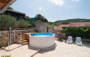 a hot tub in the backyard of a house at One-Bedroom Holiday Home In Nerezisca in Nerežišća