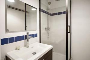 a white bathroom with a sink and a shower at Appartement Rosalia, cosy & central in Fort-de-France +4 photos