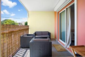 a patio with two chairs and a couch on a balcony at Appartement Rosalia, cosy & central in Fort-de-France