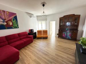 a living room with a red couch and wooden floors at Il Fauno in Contursi Terme