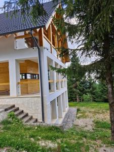 a house with a tree in front of it at Luna Retreat in Muntele Cacovei