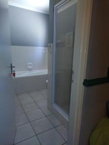 a bathroom with a shower and a tub at 27 Pendleberry Grove, Chris Hani Drive, Bela-Bela in Bela-Bela