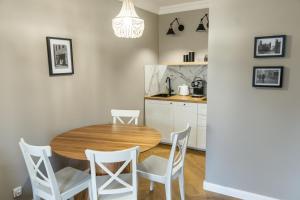 トルンにあるSOLAR Apartments I Stare Miasto 10min I Priv Parking Free I Winda I Balkonの木製のテーブルと椅子のあるキッチンとダイニングルーム