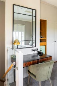 a bathroom with a vanity with a mirror and a chair at The Petersham in Richmond upon Thames