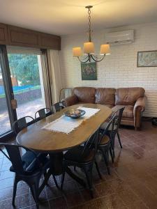 a table and chairs in a living room with a couch at Amplia, 4 dormitorios y piscina climatizada in Punta del Este