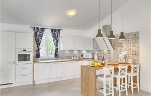 a kitchen with white cabinets and a wooden table at Villa Nada in Ružići
