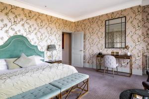 a bedroom with a bed and a desk and a mirror at The Petersham in Richmond upon Thames