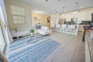 a living room with white furniture and a kitchen at La Casista in Orlando