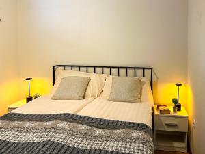 a bed in a bedroom with two night stands and two lamps at Dalmatinska Cheyf Retreat in Sarajevo