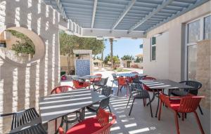 an outdoor patio with tables and chairs at Amazing Apartment In Novalja With Wifi in Novalja