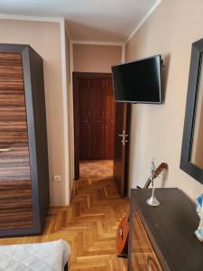 a room with a tv on the wall and a bedroom at AP Apartment in Kotor