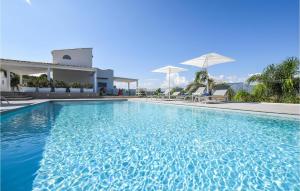 une piscine avec de l'eau bleue devant un immeuble dans l'établissement Cozy Home In Partinico With Wifi, à Partinico