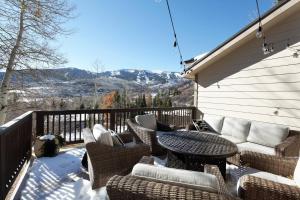 a patio with wicker chairs and a table on a balcony at Lemond Place Home in Snowmass Village
