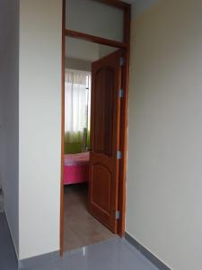 a door leading into a room with a bedroom at Kusi Wasi in Moyobamba +2 photos