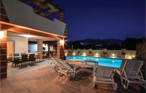 an outdoor patio with a table and chairs and a swimming pool at Gorgeous Home In Solin in Solin +19 photos