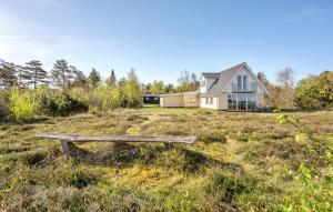 a bench in a field in front of a house at Cozy Home In Glesborg With Kitchen in Glesborg +20 photos