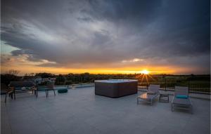 a sunset over a patio with chairs and a table at Villa La Reina Brtonigla in Brtonigla
