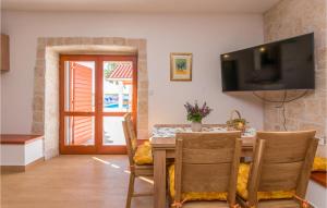 a dining room with a table and a television on the wall at Lovely Home In Stankovci in Stankovci