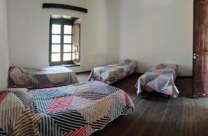 a room with three beds and a window at La Casona del Norte Jujuy in San Salvador de Jujuy +17 photos