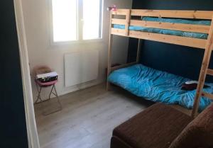 a bedroom with a bunk bed with a blue bed at maison rue de la plage in Lanobre