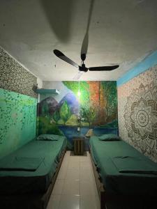 um quarto com 2 camas e uma ventoinha de tecto em Pipeline Hostel em Puerto Escondido