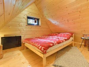 a bed in a log cabin with a television at Sękata Chata in Szczyrk