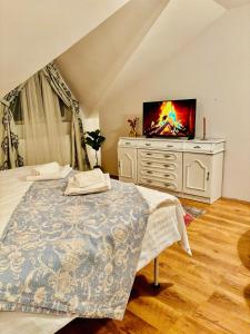 a bedroom with a bed and a television on a dresser at Confort Luxury Center Villa- langa Mitropolie si Palas in Iaşi
