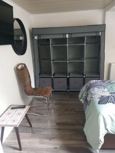 a bedroom with a bed and a chair and shelves at -Alirina- Ferienwohnung, 2 Schlafzimmern,Parkplatz in Oberkotzau