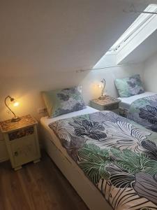 two beds in a room with two lamps on tables at -Alirina- Ferienwohnung, 2 Schlafzimmern,Parkplatz in Oberkotzau
