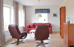 a living room with two chairs and a red couch at Two-Bedroom Holiday Home In Malilla in Bäckeby