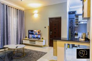 un soggiorno con televisione e tavolo di FirstChoice apartments Kampala a Kampala