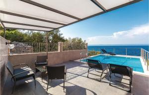 un patio con piscina, sedie e tavolo di Gorgeous Home In Prigradica With Wifi a Prigradica