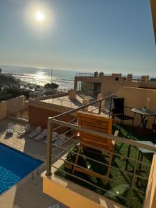 a balcony with a bench and a view of the ocean at T1 Praia Areia Branca in Lourinhã