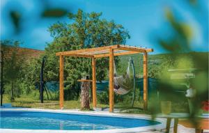 a wooden pergola next to a swimming pool at Awesome Home In Unesic in Unešić