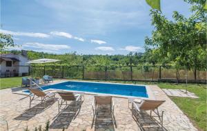 basen z krzesłami, stołem i parasolem w obiekcie Holiday Home Cere Cere Ii w mieście Santalezi