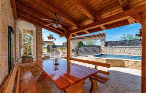 a patio with a wooden table and a swimming pool at Awesome Home In Benkovac With Wifi in Benkovac