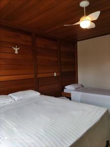 a bedroom with two beds and a ceiling fan at Chácara da Alegria in Santa Teresa +31 photos