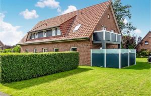 ein Haus mit einer Hecke davor in der Unterkunft Lovely Apartment In Butjadingen in Butjadingen