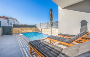 a swimming pool with two lounge chairs and an umbrella at 4 Bedroom Awesome Home In Srima in Srima +16 photos