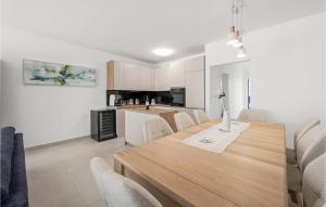a dining room and kitchen with a wooden table and chairs at 4 Bedroom Awesome Home In Srima in Srima