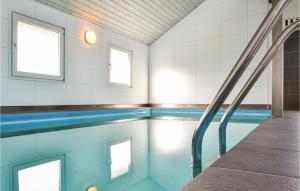 Havrvigにある4 Bedroom Gorgeous Home In Hvide Sandeの青いタイルと窓が特徴のスイミングプール